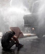 WATER BLAST: A demonstrator shelters as Turkish riot police fire a water cannon at protesters occupying a park in central Istanbul, injuring scores - http://www.stuff.co.nz/world